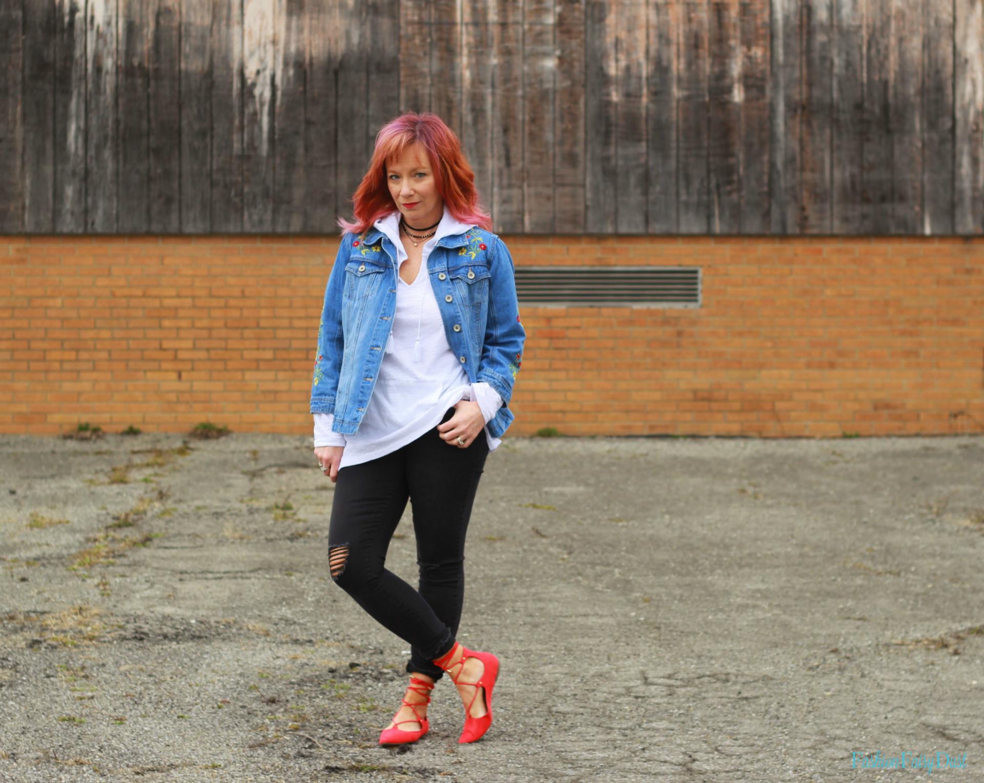 Embroidered denim jacket, white hoodie and black skinny jeans.