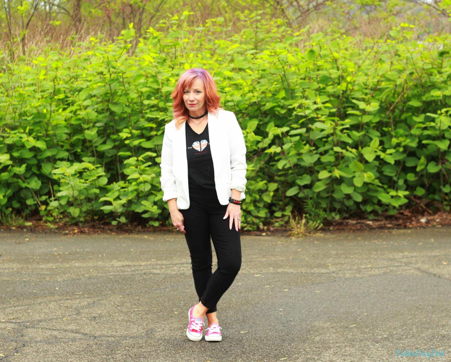 White blazer, graphic tee and black skinny pants.